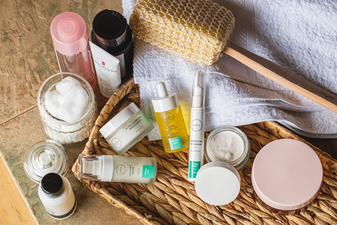 A flat lay of essential skin care products including moisturizer, serum, and cleanser on a marble background.